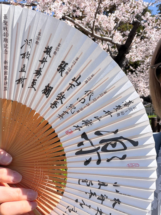 Close-up of the calligraphy, champions' names and red seals on the commemorative Go fan