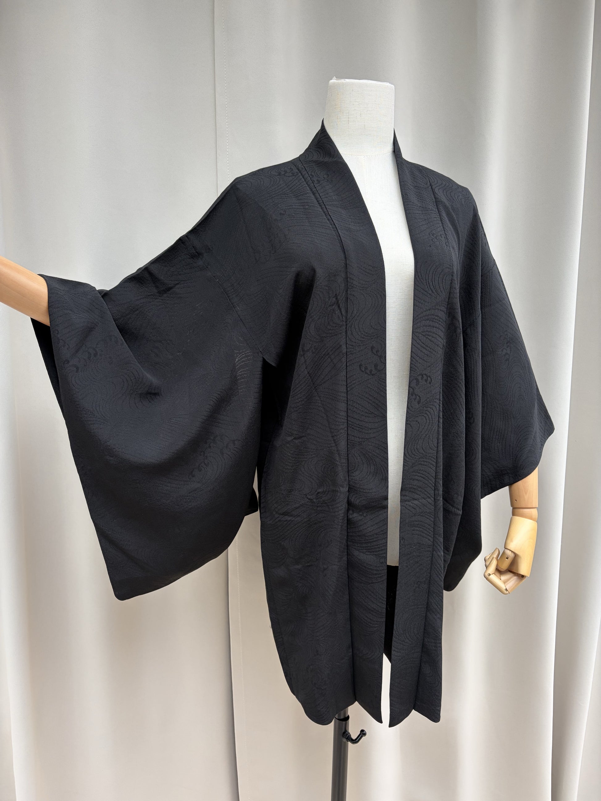 Black sheer summer haori with a woven wave pattern, front view on a mannequin