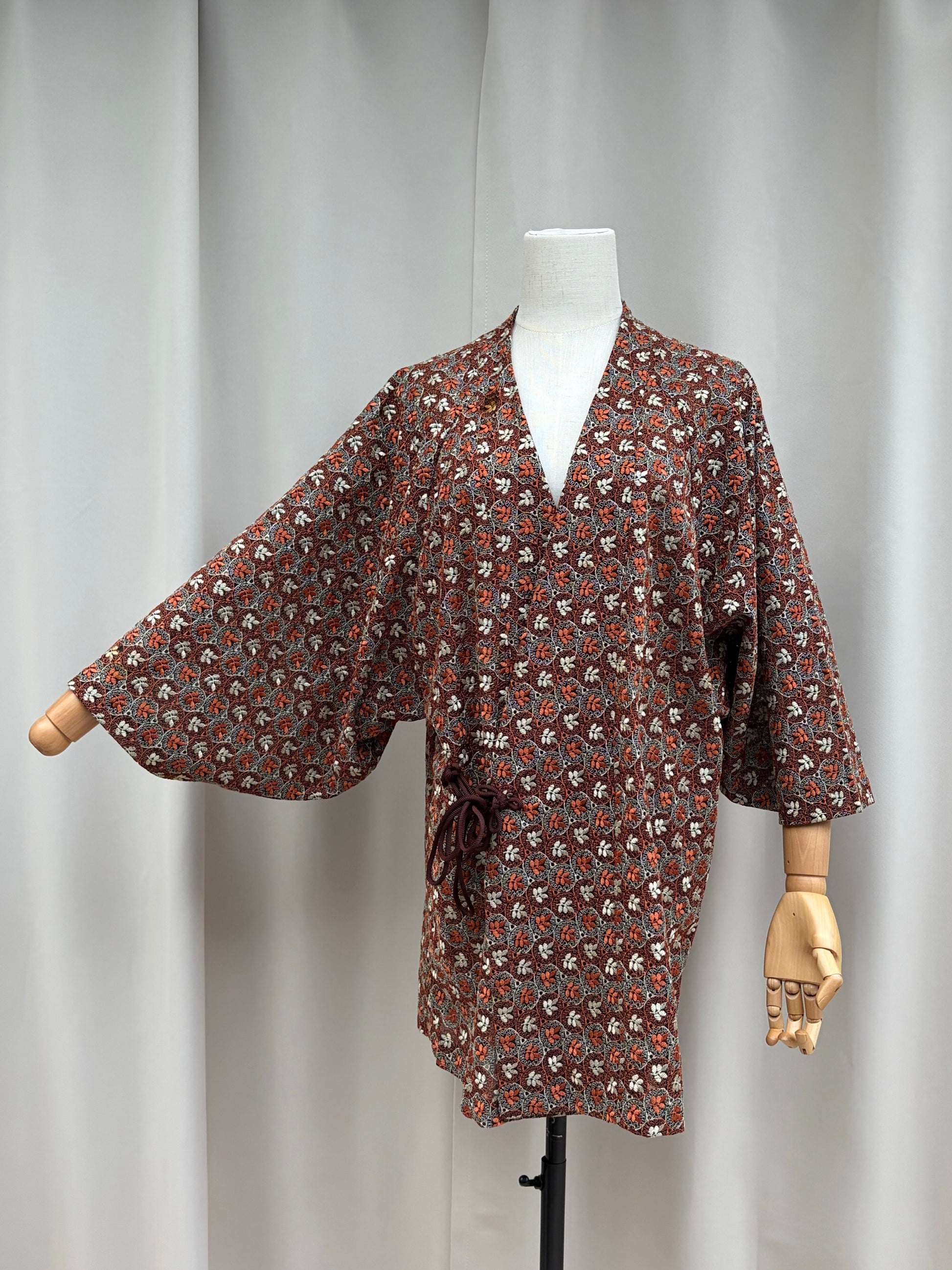 Sheer rust and cream cutwork hug-me haori displayed open on a mannequin