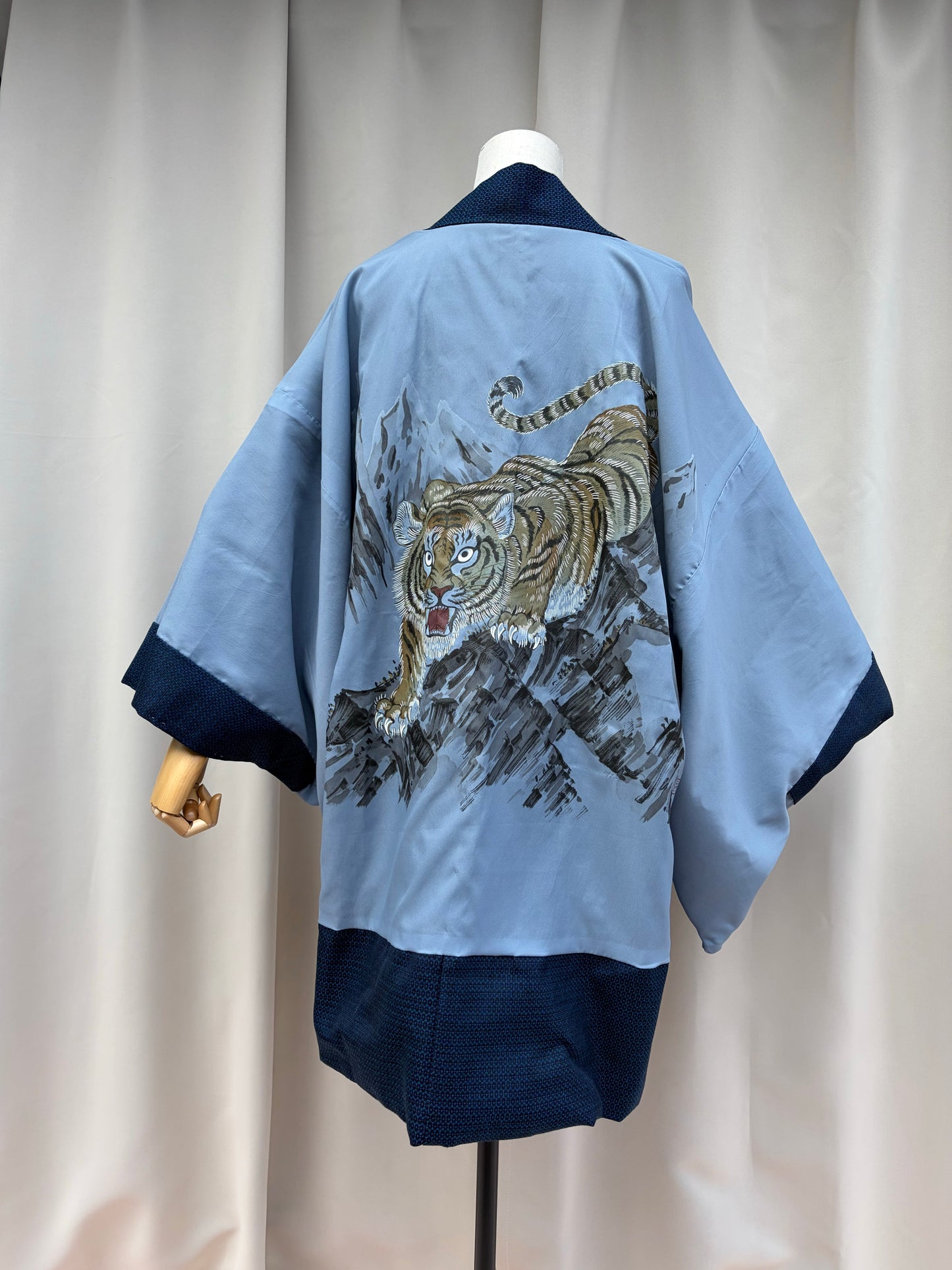 Hand-painted tiger lining of a navy Japanese men's haori shown on a mannequin