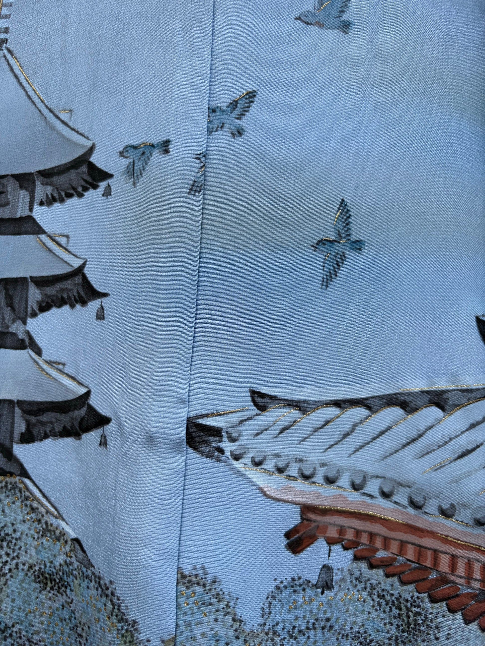 Cranes in flight over a temple roof, hand-painted with gold details