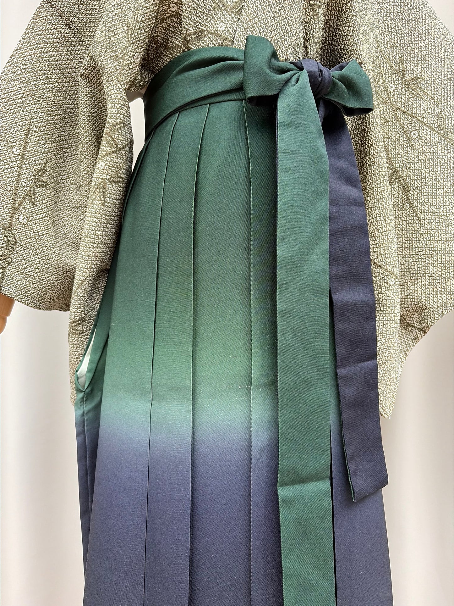 Navy-to-green ombre pleats and waist tie of the hakama