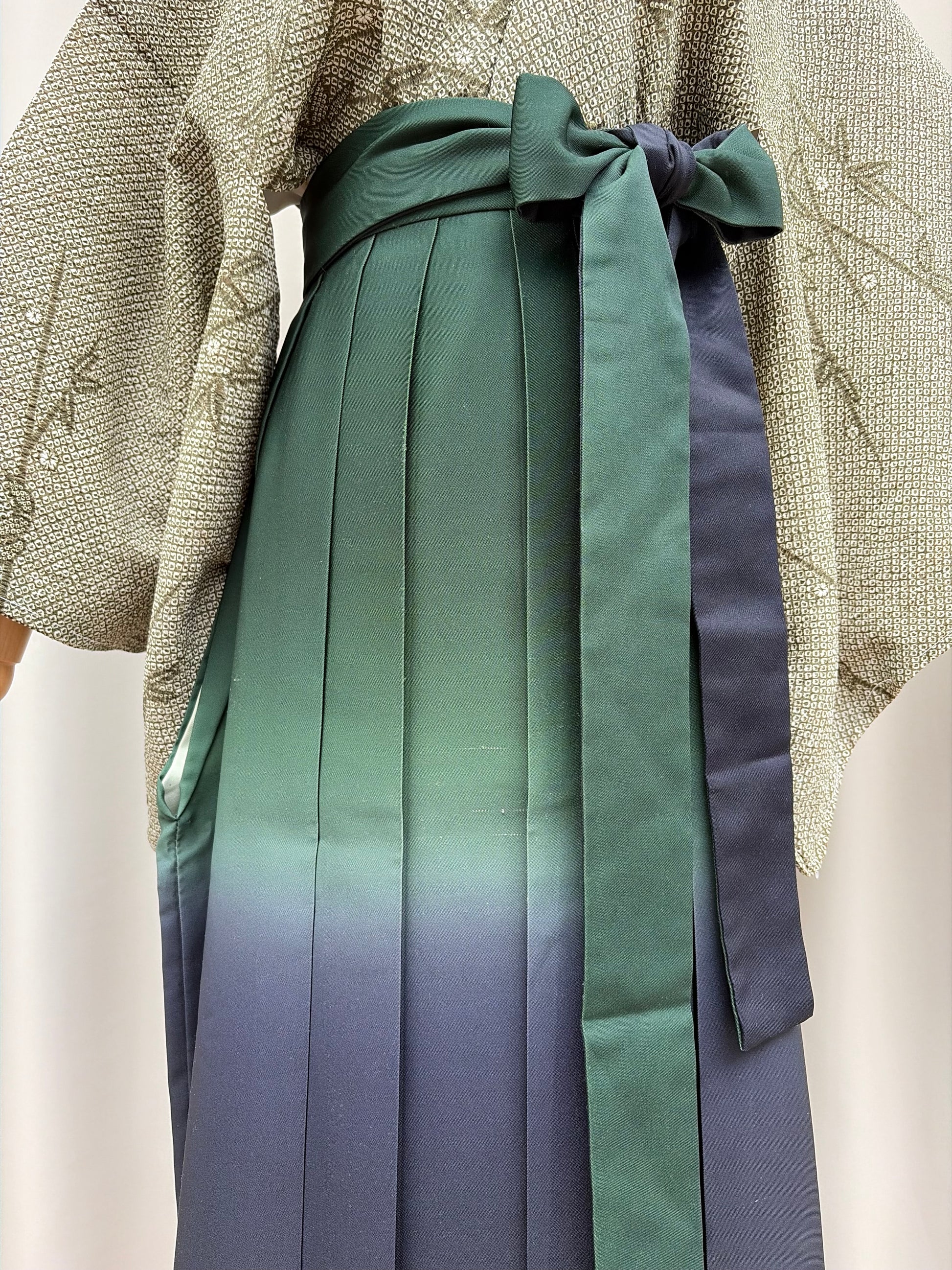 Navy-to-green ombre pleats and waist tie of the hakama