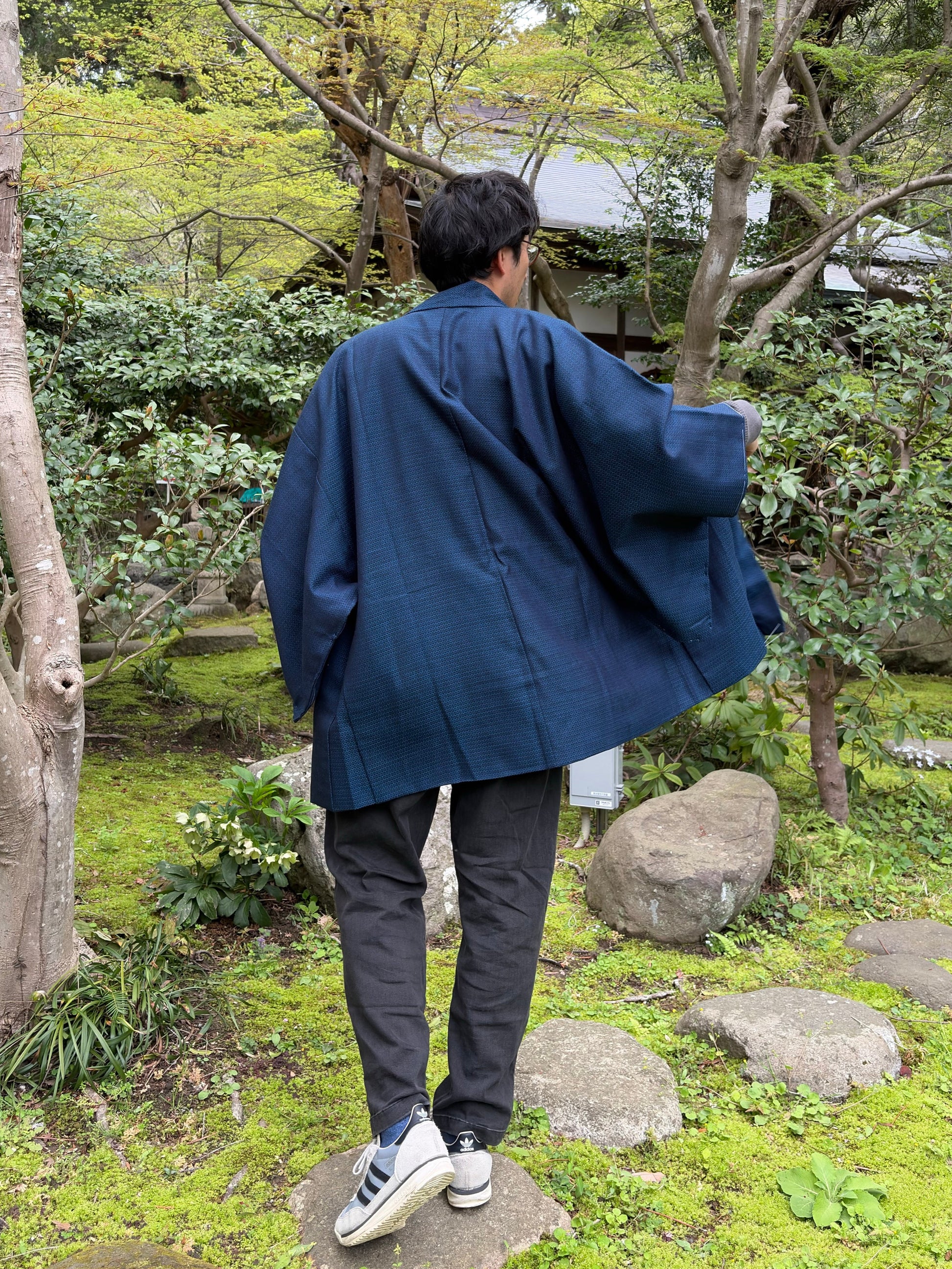 Back view of the navy men's haori worn by a model