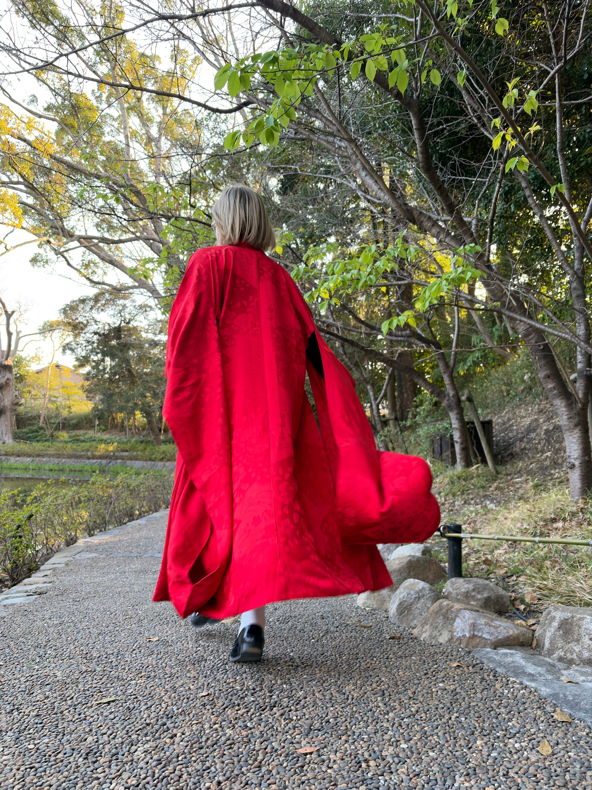 Full-length view of the red nagajuban worn as a robe in a garden
