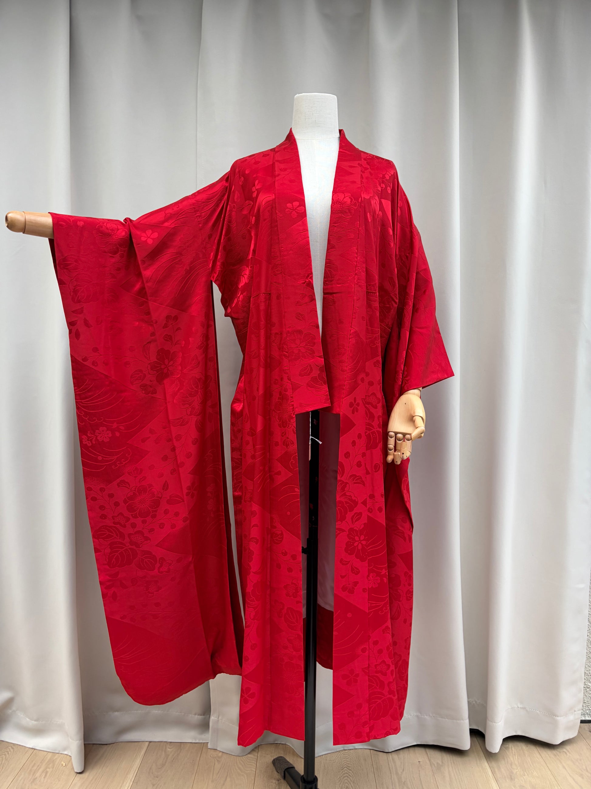 Vintage red nagajuban laid flat showing the long sleeves and red floral weave