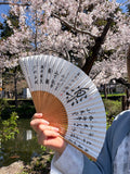 Vintage Japanese paper folding fan covered in black Go championship calligraphy with a bold central character