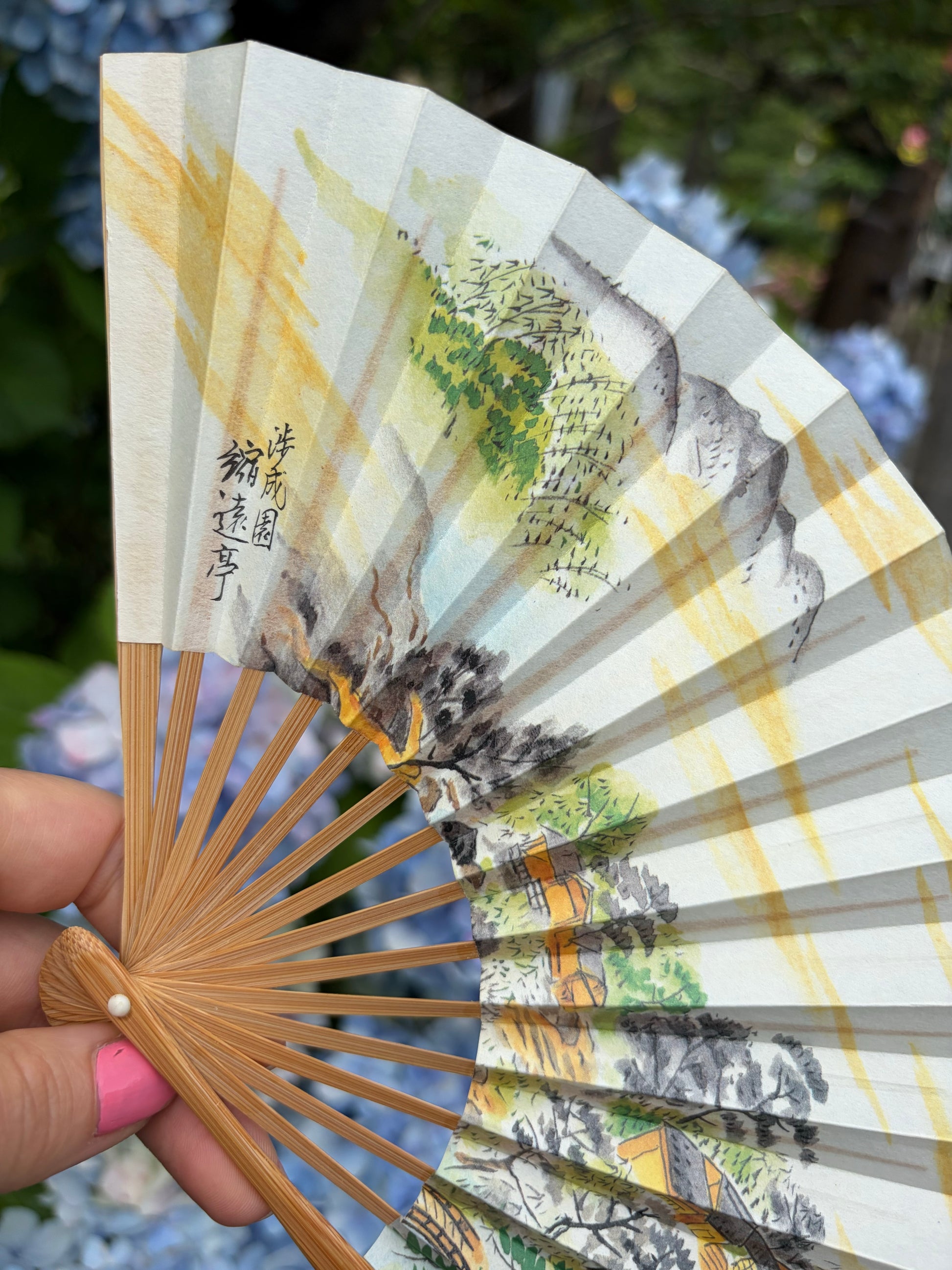Detail of the mountain landscape and artist's signature on the folding fan