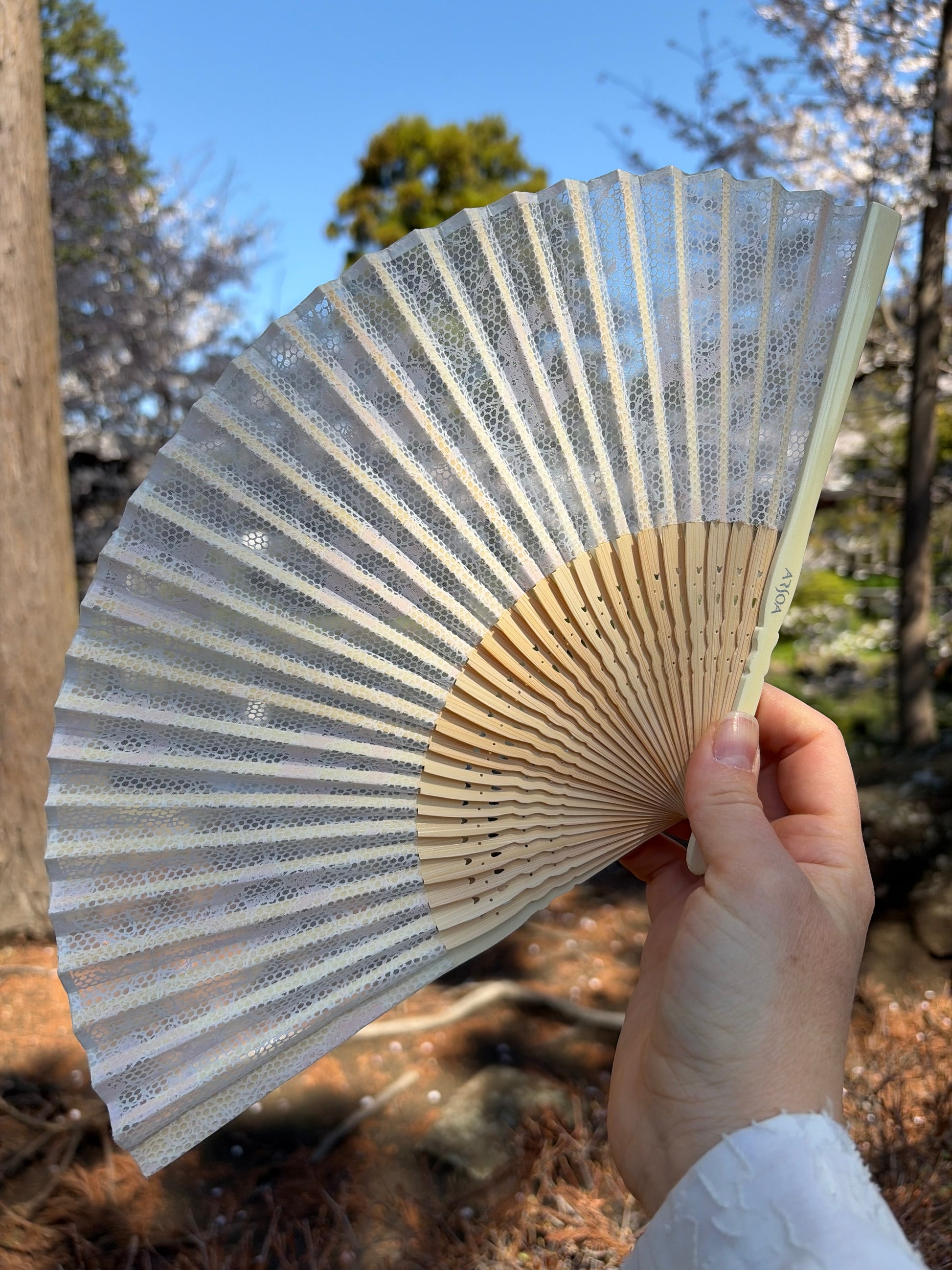 Vintage white lace Japanese folding fan open on a bamboo frame